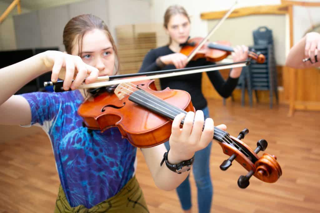 Two young girls who receive Steiner education play the violin