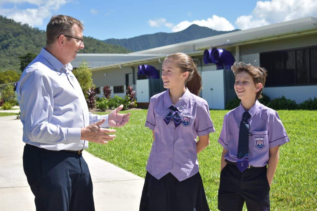 Two students at the outstanding school in Cairns, MacKillop Catholic College, talk with teacher outside 